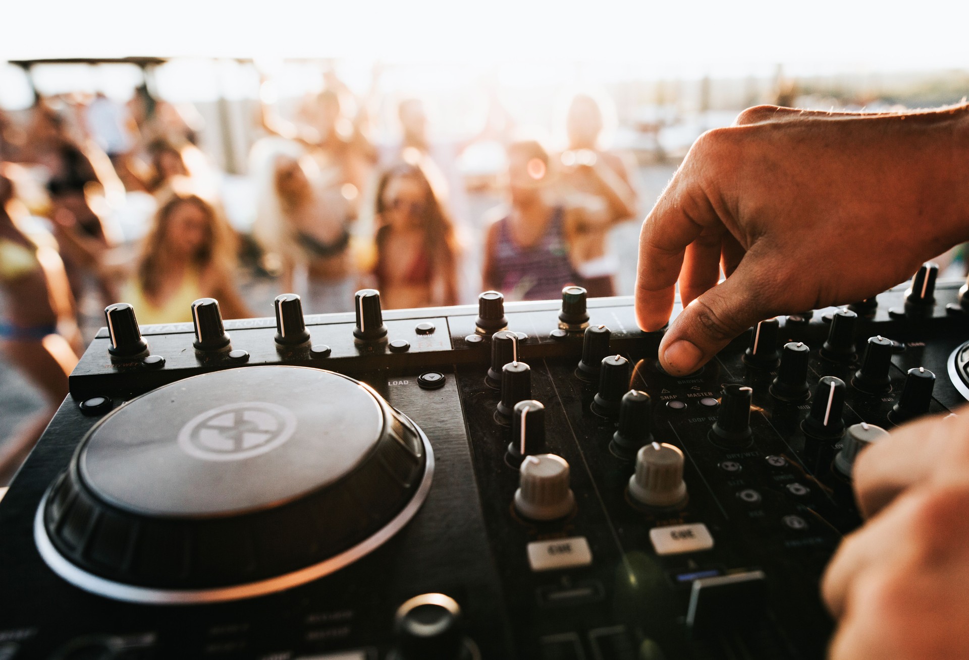 Close up of unrecognizable DJ playing music on the beach.